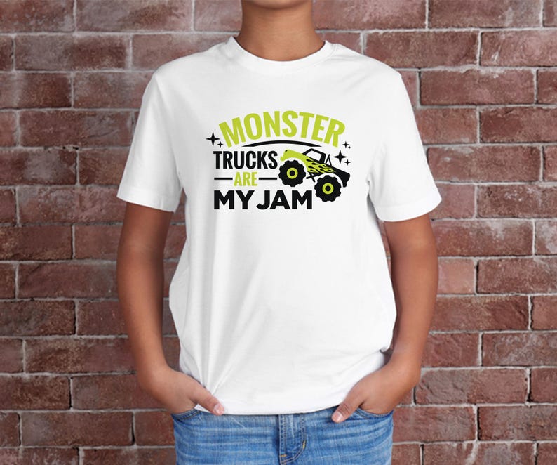 May include: White t-shirt with a green graphic that says "Monster Trucks Are My Jam" and a cartoon monster truck.