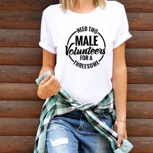 May include: White t-shirt with a black circle graphic that says "Need Two Male Volunteers For A Threesome".