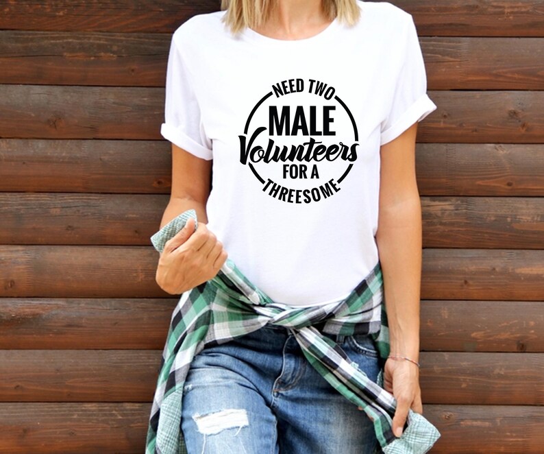 May include: White t-shirt with a black circle graphic that says "Need Two Male Volunteers For A Threesome".