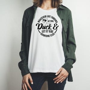 May include: White t-shirt with a black graphic of a duck wearing sunglasses and the text "Whatever life throws at you, Duck & Let it Hit Someone Else."