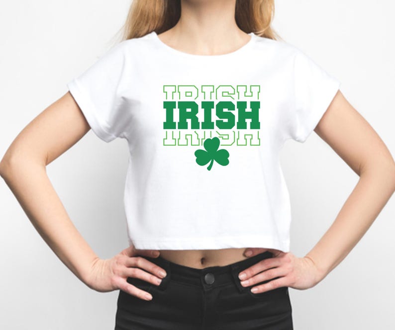 May include: White cropped t-shirt with green text that reads "IRISH" in a blocky font. A green shamrock is below the text.