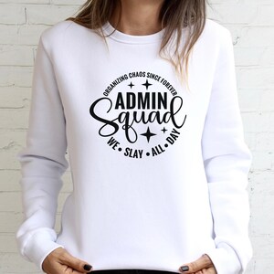 Może przedstawiać: Biała bluza z czarnym napisem "Organizing Chaos Since Forever Admin Squad We Slay All Day" z gwiazdami wok&oacute;ł tekstu.