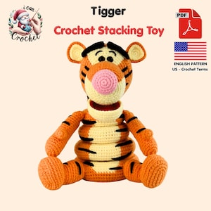May include: A crochet stacking toy shaped like Tigger, featuring orange and cream yarn with black stripes, a pink nose, and black eyes. The text reads Tigger Crochet Stacking Toy, PDF, and English Pattern US - Crochet Terms with a US flag icon.