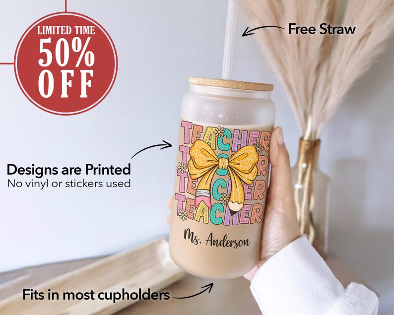 May include: A frosted glass tumbler with a colorful "Teacher" design featuring a yellow bow and a pencil. The tumbler has a bamboo lid and a straw. The text "Ms. Anderson" is printed on the bottom of the tumbler.