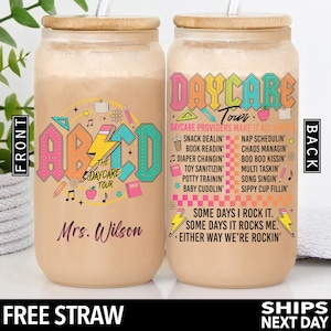 May include: Two personalized, reusable, clear plastic tumblers with bamboo lids and straws. The tumblers are decorated with a colorful ABC design and the text "The Daycare Tour" on one side and the text "Daycare Tour" with a list of daycare provider duties on the other side. The text "Mrs. Wilson" is printed on the bottom of one tumbler.