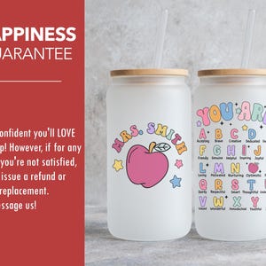 K&ouml;nnte beinhalten: Zwei gefrostete Glasbecher mit Deckeln und Strohhalmen. Ein Becher sagt "Mrs. Smith" mit einem rosa Apfel und Sternen. Der andere Becher sagt "You Are" mit dem Alphabet und positiven Adjektiven.