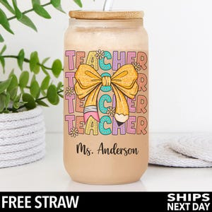 May include: A brown tumbler with a bamboo lid and a straw. The tumbler has a colorful design with the words "Teacher" and a bow with a pencil. The text "Ms. Anderson" is printed on the bottom of the tumbler.