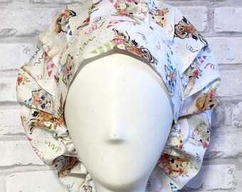 May include: White surgical scrub hat with a colorful print of animals wearing party hats. The print includes cats, dogs, and rabbits.
