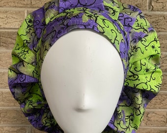 May include: A green and purple scrub hat with a spiderweb and spider design. The hat is made of a soft, comfortable fabric and is perfect for nurses, doctors, and other healthcare professionals.
