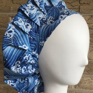 May include: Blue and white patterned surgical scrub hat with a gathered elastic band. The pattern features a wave design.