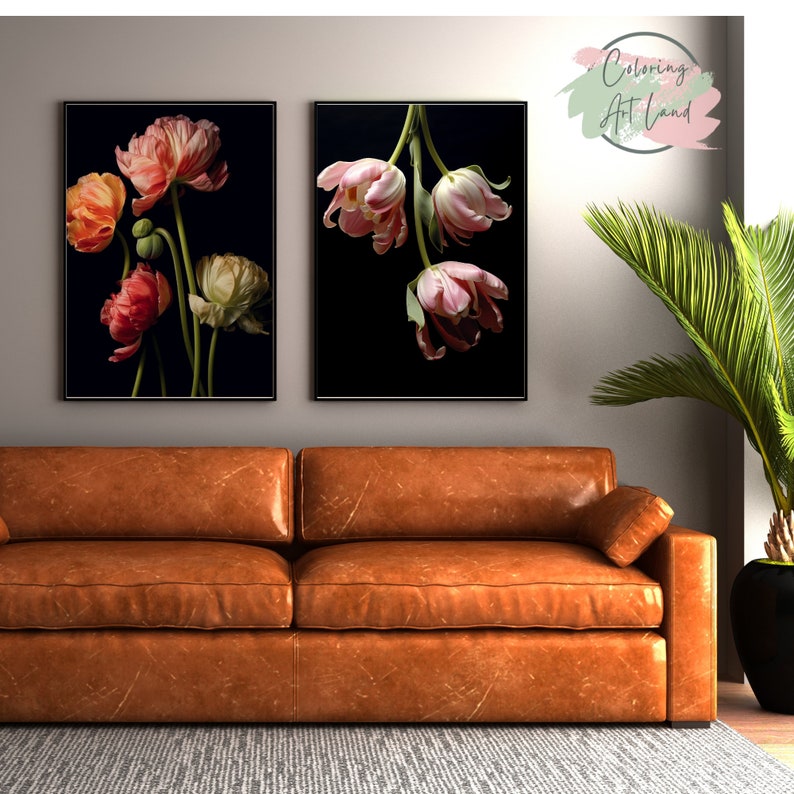 May include: Two framed prints of pink and white tulips on a black background. The prints are hanging on a wall above a brown leather couch.