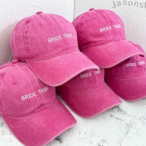 Könnte beinhalten: Vier rosafarbene Baseballkappen mit weißer Stickerei, auf der "Bride Tribe" steht.