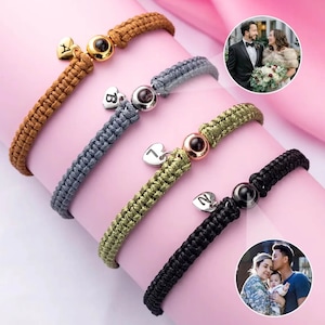 May include: Four friendship bracelets with different colored cords and charms. Each bracelet has a small heart charm with a letter on it and a round bead with a photo inside. The photos show a couple and a family.