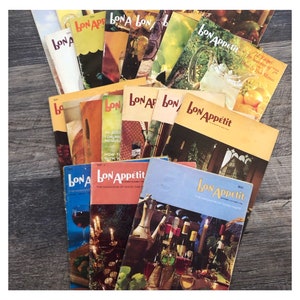 May include: A stack of vintage Bon Appetit magazines from the 1950s and 1960s. The covers feature colorful illustrations and text, including "72 Recipes for Summer of '72" and "The Magazine of Good Taste".