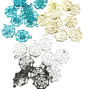 May include: A selection of spiderweb charms in teal, gold, silver, and black. Each charm features a detailed spiderweb design and a small loop for attachment. These charms are suitable for jewellery making or craft projects. Measurements are not available.