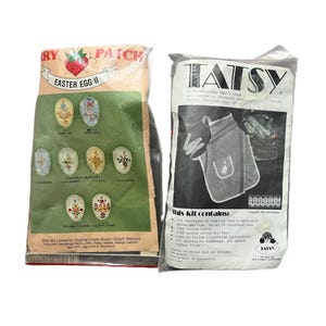 Puede incluir: Se muestran dos kits de manualidades. Uno es un kit "RY PATCH" para Easter Egg II, con diseños de huevos. El otro es un kit "TATSY" para un delantal de chef con apliques de ganso y encaje tatted. Ambos kits están en envases de plástico.