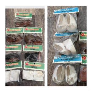 Może przedstawiać: Kolekcja vintage'owych butów dla lalek w różnych stylach i kolorach, w tym buty wiązane i buty z paskiem w kształcie litery T. Buty są zapakowane w plastikowe torebki z etykietami z napisem "Doll Baby" i "The Original Doll Baby".