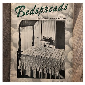 May include: Vintage book cover titled "Bedspreads to Knit and Crochet." The image shows a bed with a detailed, fringed bedspread. The background features a four-poster bed and a window, with a backdrop of yarn balls.