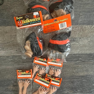 May include: Several Halloween craft supplies are displayed, including witch heads and witch hands. The witch heads have black hats with orange bands and tan faces. The hands are a flesh tone. Each item is packaged with a Darico Halloween Craft Supplies label.