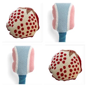 May include: Four colorful, textured decorative objects. Two are shaped like a fruit with a cream-colored base and red dots. The other two have a blue, pink, and white design with a blue stem. The objects are likely handmade.