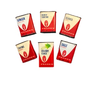 May include: A collection of vintage spice tins from Frank's, featuring labels for ginger, cream of tartar, cloves, thyme, celery flakes, and sage. Each tin has a red and white design with the brand name.
