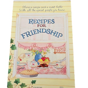 May include: A notepad with a window design, featuring the text "Recipes for Friendship." The illustration shows a table set with a pie, teapot, and fruit. The notepad measures 5.5 inches by 8 inches.