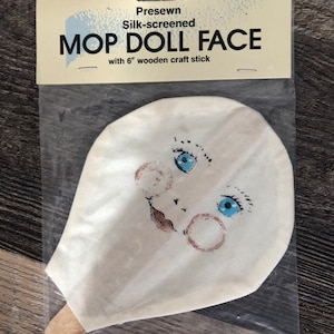 Mop Doll Face. Blauwe ogen, maanvormig gezicht. Nieuw, ongebruikt exemplaar. Voorgenaaide zeefdruk.