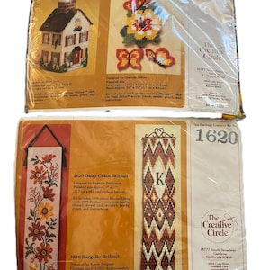 May include: Four craft kits are visible, including a tissue box cover, butterfly designs, and two bellpulls. The bellpulls feature floral and geometric patterns. The kits include canvas, yarn, needles, and instructions. The tissue box cover kit features a house design.