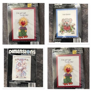 May include: Four packaged counted cross stitch kits including two Janlynn Suzy's Zoo kits featuring a duck with the text I've just got to be me, one Janlynn Suzy's Zoo kit with a koala and God Bless text, and one Dimensions Victorian Carousel kit.