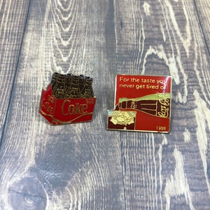 Two vintage authentic Coca-Cola lapel pins. Preowned good condition. 1990s