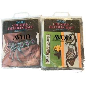 May include: Two vintage Avon Creative Needlecraft crewel embroidery kits. One kit features a brown belt with a colorful floral design. The other kit features a tree owl wall hanging with a brown owl on a branch with yellow flowers.