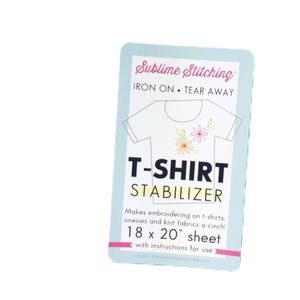 May include: A rectangular package for T-shirt stabilizer. The package is light blue with the words "Sublime Stitching" and "IRON ON • TEAR AWAY" at the top. The text "T-SHIRT STABILIZER" is in bold, and the sheet measures 18 x 20 inches.