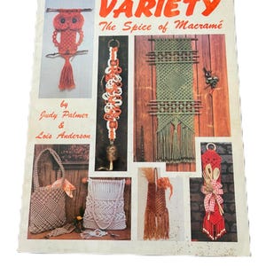 May include: A vintage book cover titled "Variety: The Spice of Macramé" with various macramé projects. The cover features an owl, wall hangings, bags, and other macramé items. The book is by Judy Palmer & Lois Anderson.