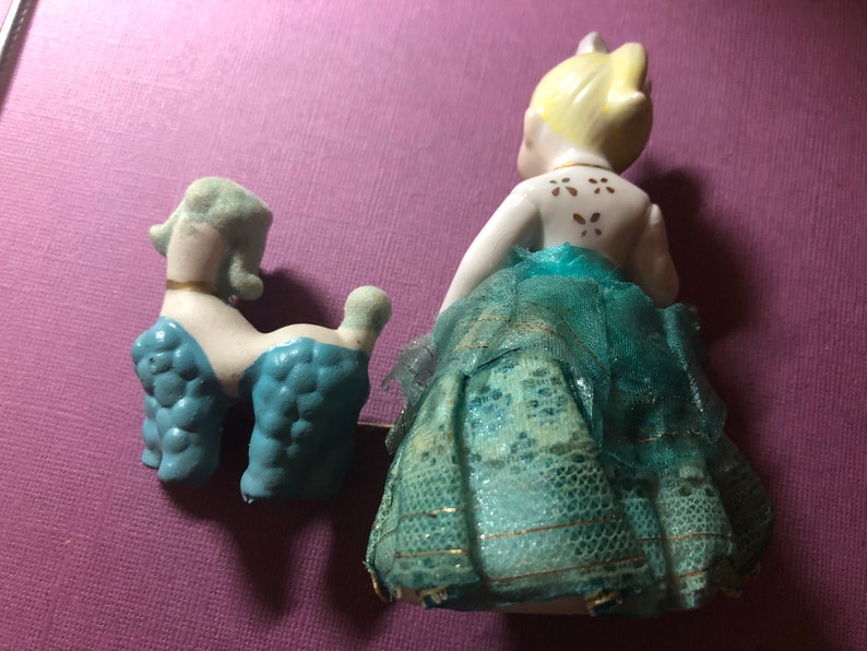 She is wearing a blue lace dress Vintage Antique Girl figurine with blue poodle 50s era.