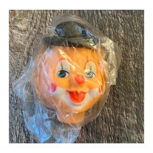 Vintage klein clownspoppenhoofd. Echt blond haar, zwarte hoed, clowngezicht. Ongeveer 3 1/2"
