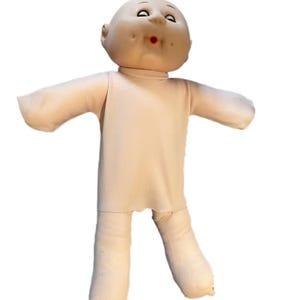 May include: A vintage doll with a bald head, painted facial features, and a light beige fabric body. The doll has outstretched arms and legs, and a slightly open mouth. The doll's overall appearance suggests a classic toy.