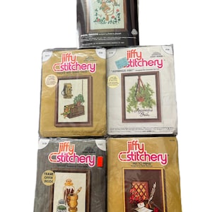 May include: Four vintage Jiffy Stitchery cross stitch patterns. The patterns are for "Spring Training", "Phone and Cedar Chest", "Asparagus Fern", and "Pen to Paper".