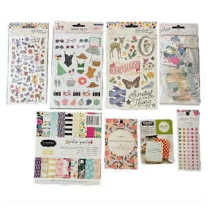 May include: A collection of scrapbooking supplies, including sticker sheets, paper pads, and embellishments. The sticker sheets feature various designs, such as butterflies, flowers, and beach-themed elements. The paper pads have floral and patterned designs. The color palette includes pastels and bright colors.