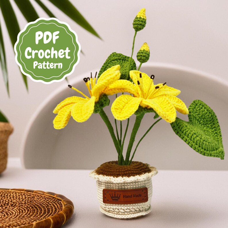 May include: Crocheted yellow flowers in a white pot with a brown base. The pot has a label that says "Hand Made".