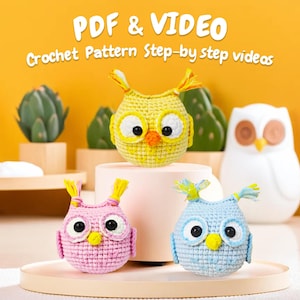 Peut inclure: Trois jouets en crochet amigurumi en forme de hibou. Les hiboux sont jaunes, roses et bleus. Les hiboux sont assis sur un piédestal blanc avec une base en bois. Le texte "PDF & VIDEO Crochet Pattern Step-by-step videos" est au-dessus des hiboux.