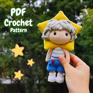 Op de afbeelding: Gehaakte pop met een gele ster hoofdtooi en een blauwe korte broek. De pop heeft grijs haar en een rode ster. De afbeelding bevat de tekst "PDF Crochet Pattern" en gele ster illustraties.