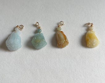 May include: Four gemstone pendants in a row, each with a unique color and design. The pendants are in shades of light blue, green, orange, and yellow. Each pendant has a gold-colored loop at the top for hanging.