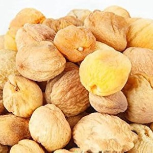 Op de afbeelding: Een close-up van een stapel gedroogde abrikozen. De abrikozen zijn licht oranje van kleur en hebben een gerimpelde textuur.