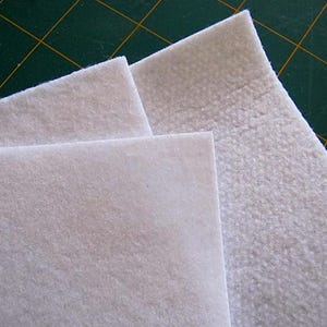 Puede incluir: Tres piezas de tela blanca, dos son lisas y una es texturizada. La tela se utiliza para acolchar y manualidades.