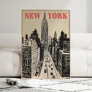 May include: A black and white illustration of the New York City skyline, featuring the Empire State Building and other skyscrapers. The image has a vintage aesthetic and includes the text "NEW YORK" in red.