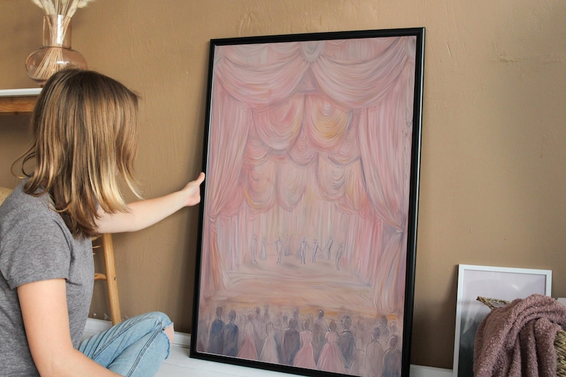 May include: A framed painting depicting a stage with pink curtains and a crowd of people in the foreground. The painting is done in a soft, pastel style.