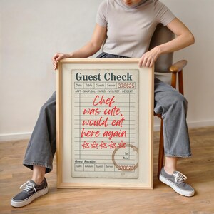 May include: A framed print resembling a vintage guest check. The text "Guest Check" is at the top, with fields for date, table, guests, and server. Red text reads "Chef was cute, would eat here again" with star ratings and a coffee ring.