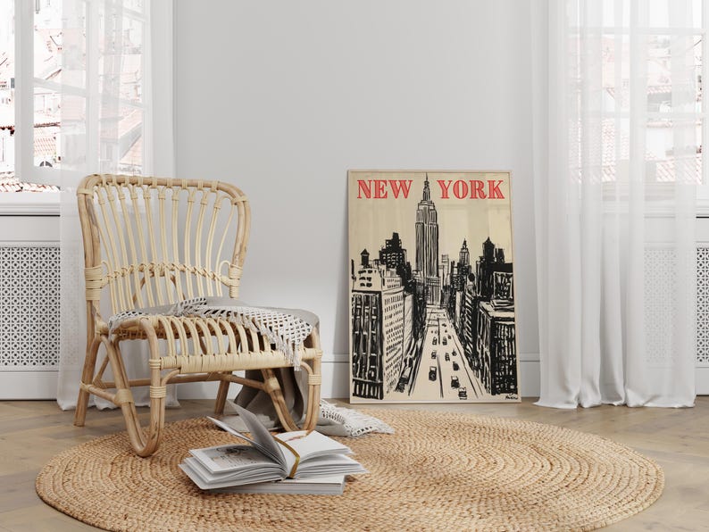 May include: A wicker chair with a woven seat and back sits in a room with a large window and a poster on the wall. The poster is a black and white illustration of the New York City skyline with the text "NEW YORK" in red letters.