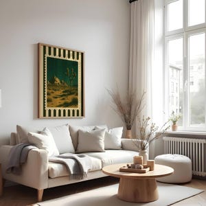 May include: A framed desert landscape art print featuring a Joshua tree under a starry night sky. The artwork has a gold and black border and is displayed above a white sofa in a living room setting. The room is decorated with neutral tones.