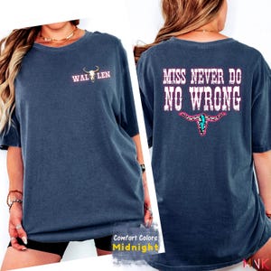 May include: Midnight blue Comfort Colors t-shirt. The front features the text "WAL LEN" with a bull skull graphic. The back displays "MISS NEVER DO NO WRONG" in pink and white, with a bull skull graphic.